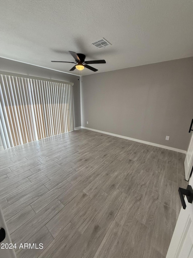 2429 E Alameda Dr, Tempe, AZ 85282 - empty room with a ceiling fan, wood finished floors, a textured ceiling, baseboards, and visible vents
