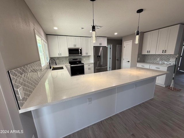 kitchen featuring kitchen peninsula, dark hardwood / wood-style flooring, stainless steel appliances, and white cabinets