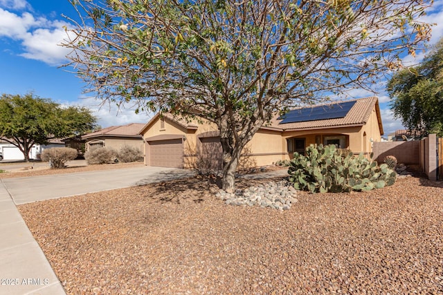 ranch-style home featuring a garage and solar panels