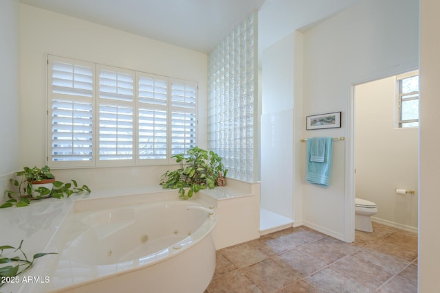 full bathroom featuring a tub with jets, a wealth of natural light, and toilet