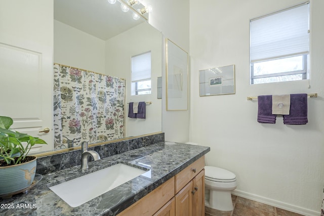 bathroom with curtained shower, vanity, toilet, and baseboards