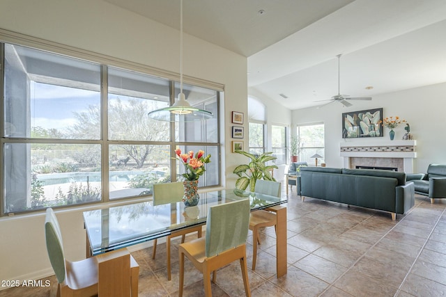 dining area featuring vaulted ceiling, a fireplace, and ceiling fan