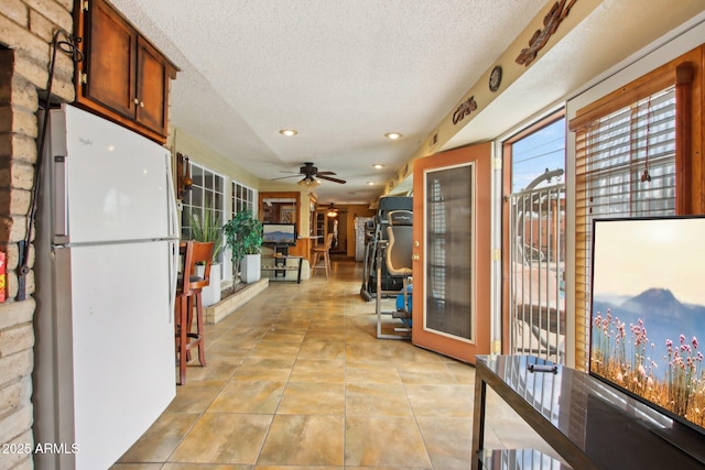 hallway with light tile patterned floors, recessed lighting, and a textured ceiling