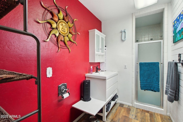 bathroom featuring vanity, wood finished floors, and a stall shower