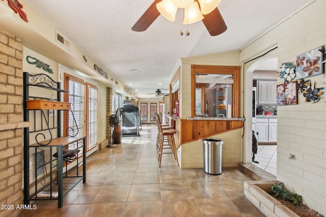 kitchen featuring visible vents, a textured ceiling, a ceiling fan, and tile patterned flooring