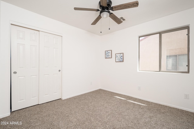 unfurnished bedroom with carpet flooring, ceiling fan, and a closet