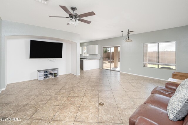 unfurnished living room with ceiling fan, plenty of natural light, and light tile patterned floors