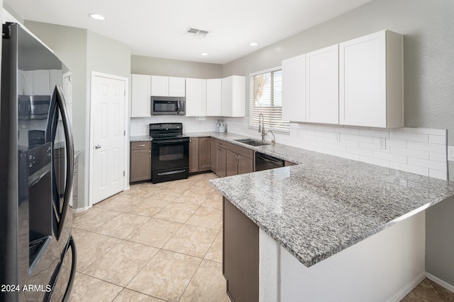 kitchen featuring light stone counters, sink, kitchen peninsula, white cabinetry, and stainless steel appliances