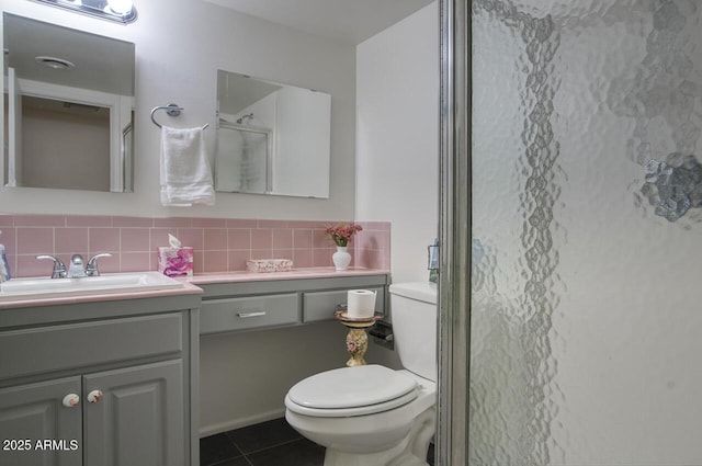 1107 W Osborn Rd Unit 213, Phoenix, AZ 85013 - bathroom featuring vanity, a shower with door, tile patterned flooring, and decorative backsplash