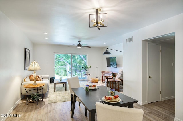 1107 W Osborn Rd Unit 213, Phoenix, AZ 85013 - dining area featuring light wood-style floors, ceiling fan, a chandelier, and recessed lighting