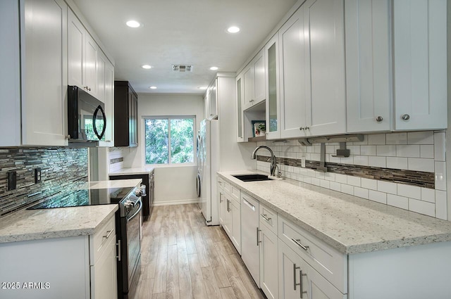 1107 W Osborn Rd Unit 213, Phoenix, AZ 85013 - kitchen featuring black microwave, electric range oven, freestanding refrigerator, light wood finished floors, and tasteful backsplash