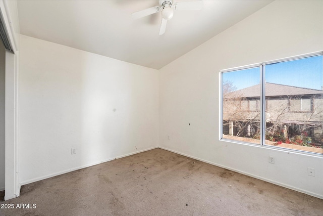 spare room with vaulted ceiling, carpet, and ceiling fan