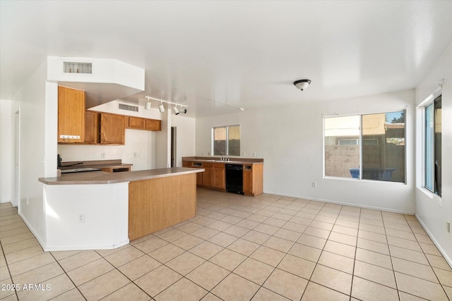 kitchen featuring light tile patterned flooring, black dishwasher, sink, and kitchen peninsula