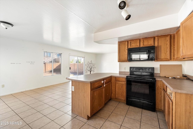 kitchen with light tile patterned flooring, kitchen peninsula, and black appliances