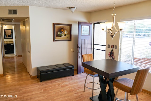 dining space featuring a textured ceiling and light hardwood / wood-style flooring