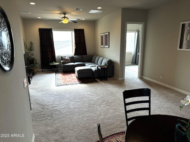 living room with ceiling fan, plenty of natural light, and light carpet