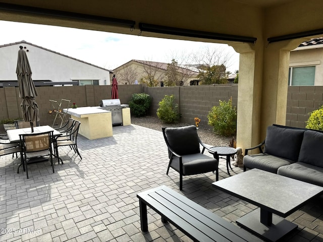 view of patio / terrace with an outdoor hangout area, grilling area, and an outdoor kitchen