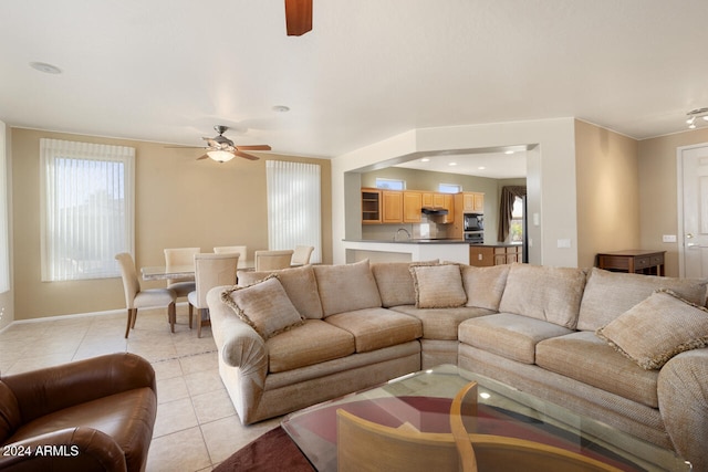 tiled living room featuring ceiling fan and a wealth of natural light