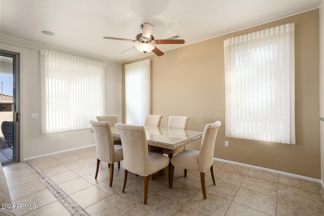 tiled dining space featuring ceiling fan