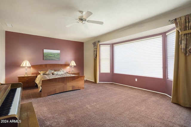 carpeted bedroom featuring multiple windows and ceiling fan