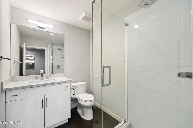 bathroom with hardwood / wood-style flooring, vanity, toilet, and an enclosed shower