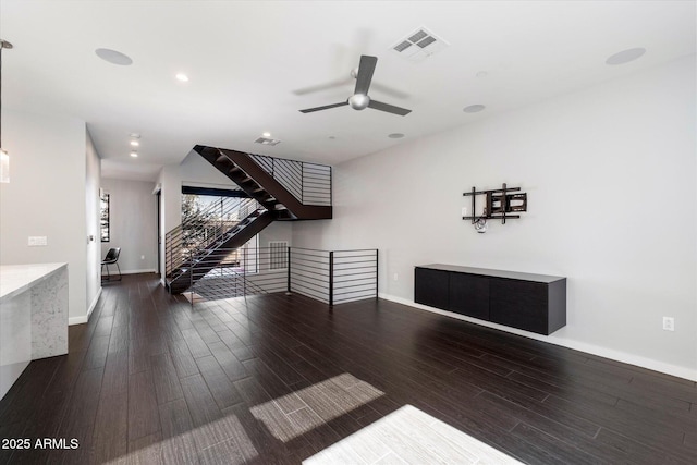 unfurnished living room with dark hardwood / wood-style flooring and ceiling fan