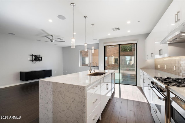 kitchen featuring sink, dark wood-type flooring, white cabinets, and high end stove