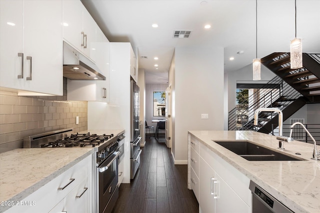 kitchen featuring white cabinetry, stainless steel gas range oven, light stone countertops, and dishwasher