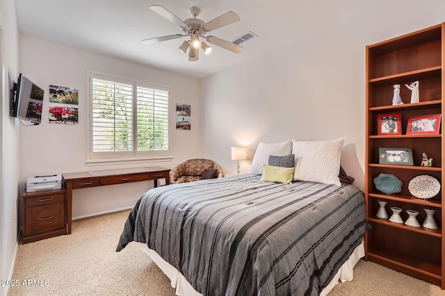 bedroom with visible vents, light colored carpet, and ceiling fan