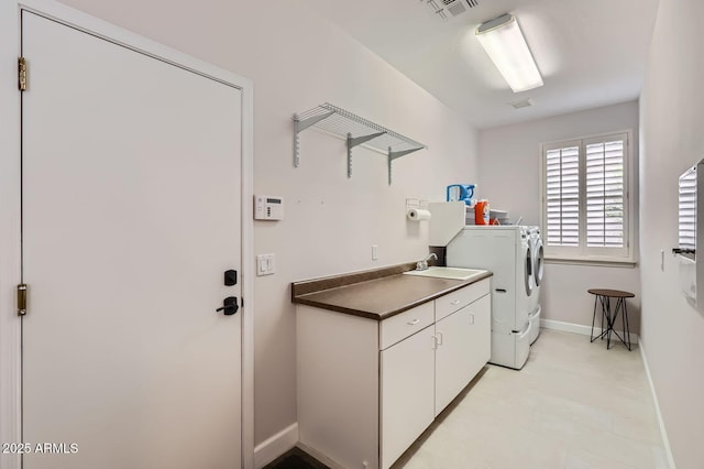 laundry area with visible vents, washer and dryer, a sink, cabinet space, and baseboards