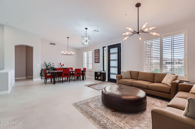 living room featuring arched walkways, visible vents, baseboards, and an inviting chandelier