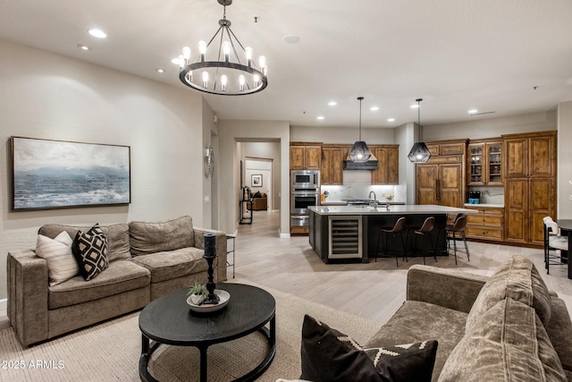 living room featuring wine cooler, light wood finished floors, and recessed lighting