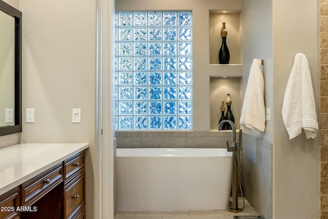 full bathroom with a freestanding bath and vanity