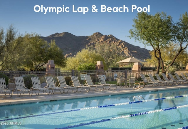 pool with a patio, fence, and a mountain view