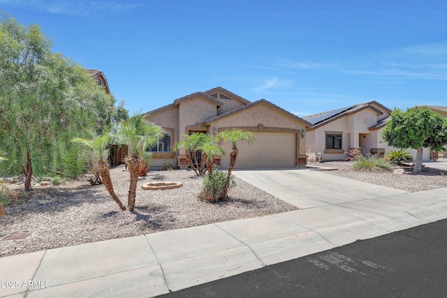 1384 S 222nd Ln, Buckeye, AZ 85326 - view of front of house featuring stucco siding, an attached garage, roof mounted solar panels, and concrete driveway