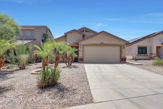 1384 S 222nd Ln, Buckeye, AZ 85326 - view of front facade with a garage, stucco siding, and driveway
