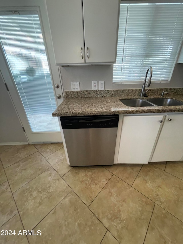 kitchen with sink, white cabinetry, light tile floors, and stainless steel dishwasher