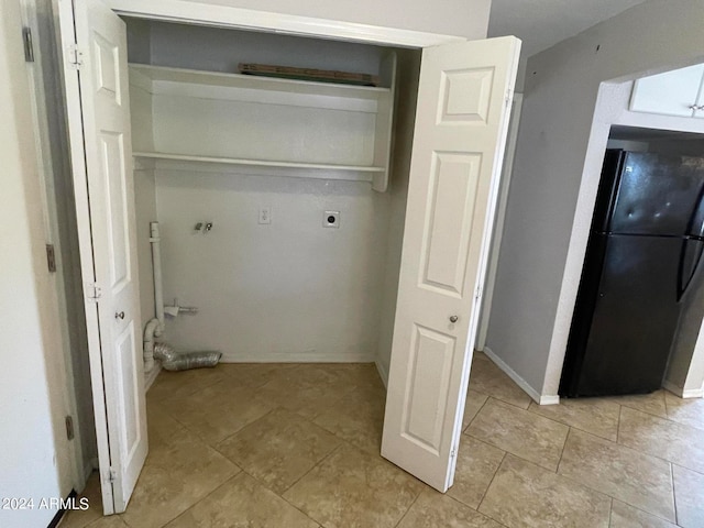 clothes washing area featuring electric dryer hookup and light tile floors