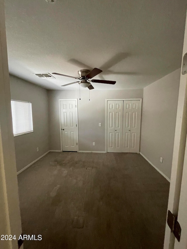 empty room featuring ceiling fan and carpet