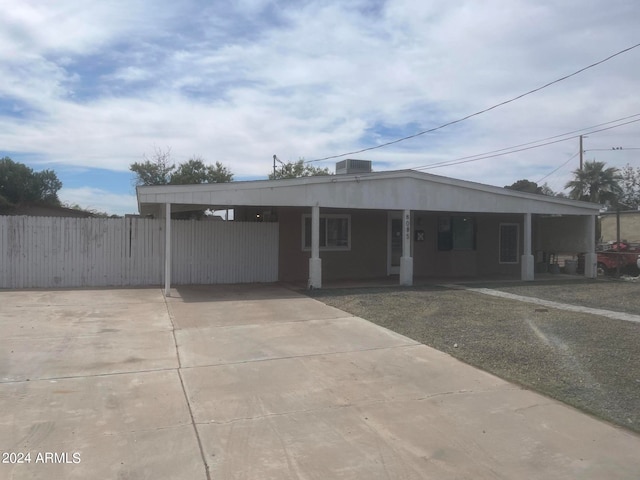 view of front facade with central AC unit and a carport