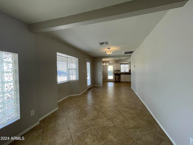 spare room featuring a wealth of natural light and tile floors