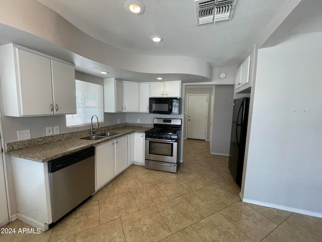 kitchen with light tile floors, white cabinets, black appliances, and sink