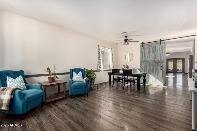 interior space featuring dark wood-type flooring, a barn door, and a healthy amount of sunlight