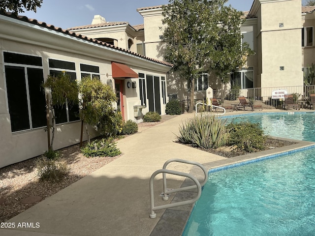 community pool featuring a patio and fence