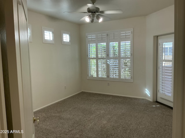 carpeted empty room featuring a ceiling fan