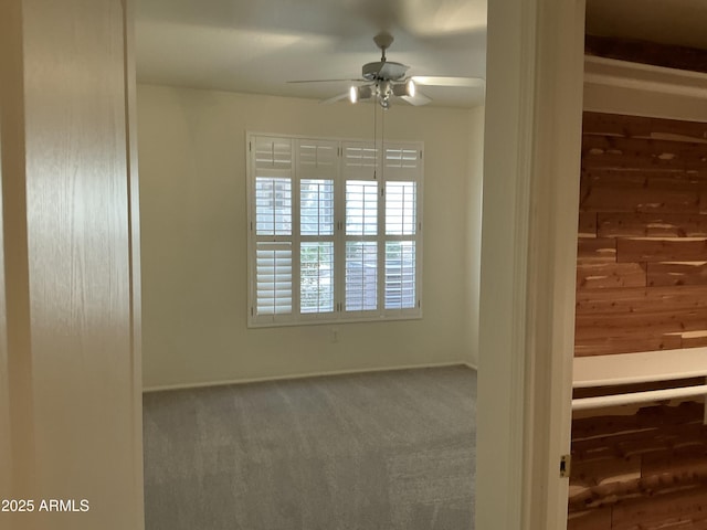 carpeted spare room with ceiling fan