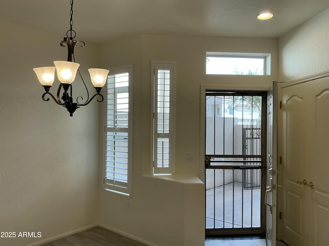 entryway with a chandelier and baseboards