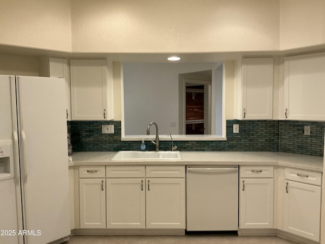 kitchen with dishwasher, white refrigerator with ice dispenser, a sink, and white cabinets