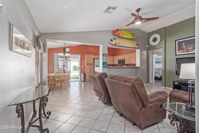 living area featuring ceiling fan with notable chandelier, vaulted ceiling, visible vents, and light tile patterned floors