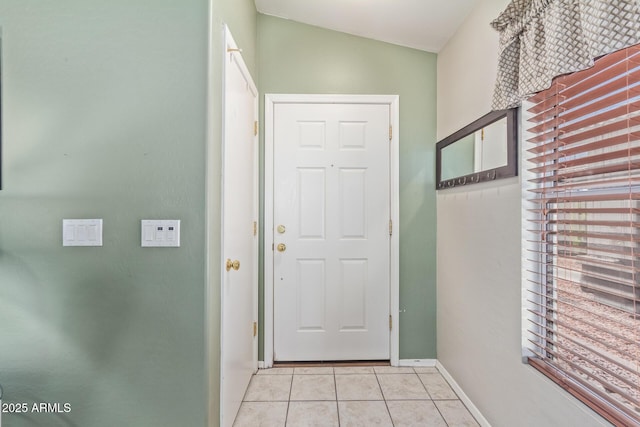 doorway featuring tile patterned floors and baseboards